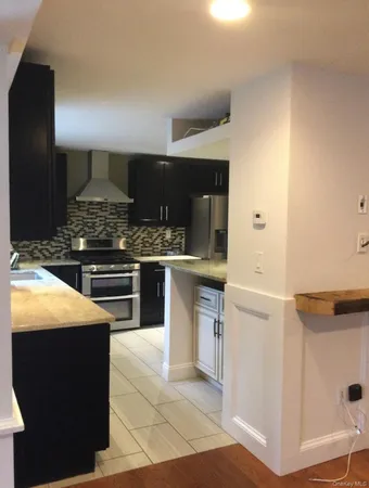 a kitchen with stainless steel appliances kitchen island granite countertop a stove a sink and a microwave