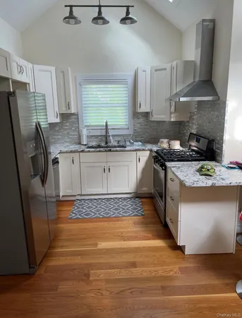 a kitchen with stainless steel appliances granite countertop a stove a sink dishwasher and a refrigerator