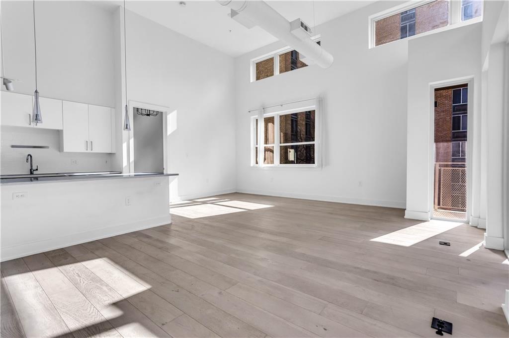 775 Juniper Street Northeast, Unit 619 Atlanta, GA 30308 - Photo 5 of 26 a view of a kitchen with wooden floor and a sink