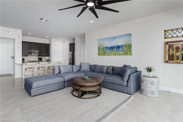 a living room with furniture and a view of kitchen