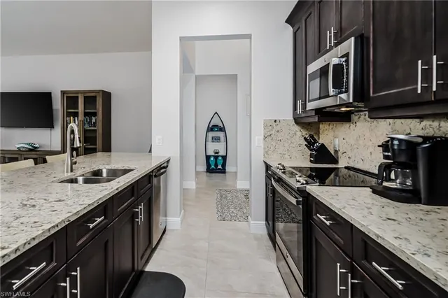 a kitchen with stainless steel appliances granite countertop a sink a stove and cabinets