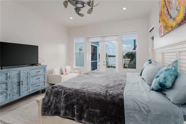 a bedroom with a large bed and flat tv screen on dresser