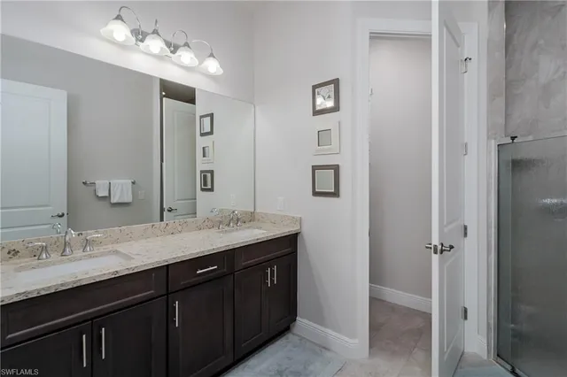 a bathroom with a granite countertop sink a mirror and a shower