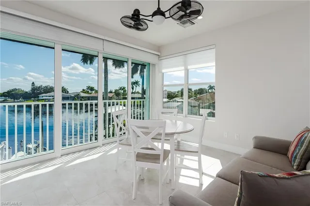 a dining room with furniture water view and a floor to ceiling window