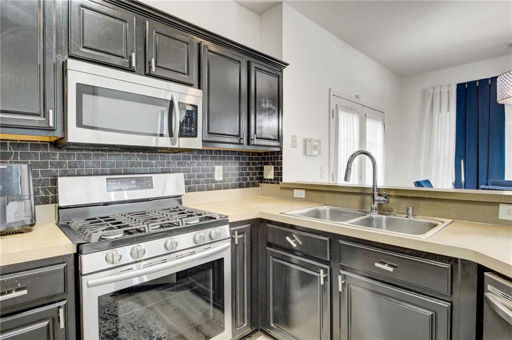 105 Fate Court Dallas, GA 30157 - Photo 12 of 32 a kitchen with stainless steel appliances granite countertop a sink stove and cabinets