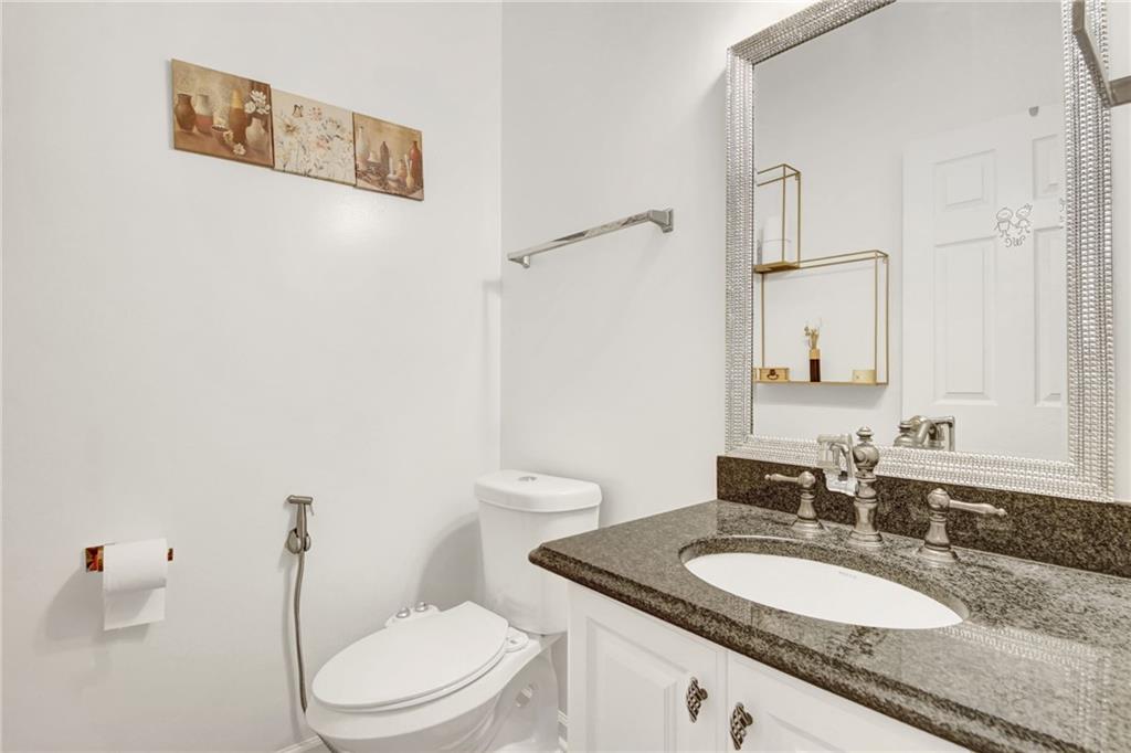 105 Fate Court Dallas, GA 30157 - Photo 18 of 32 a bathroom with a granite countertop toilet a sink and a mirror