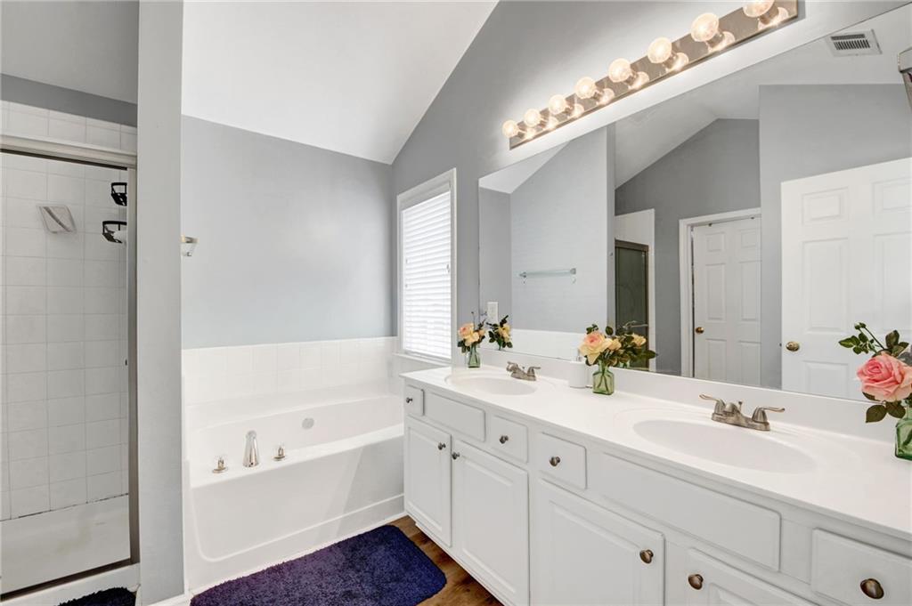 105 Fate Court Dallas, GA 30157 - Photo 21 of 32 a bathroom with a tub a double vanity sink and mirror