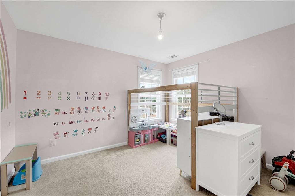 105 Fate Court Dallas, GA 30157 - Photo 25 of 32 a room with a baby bed a couch and a window