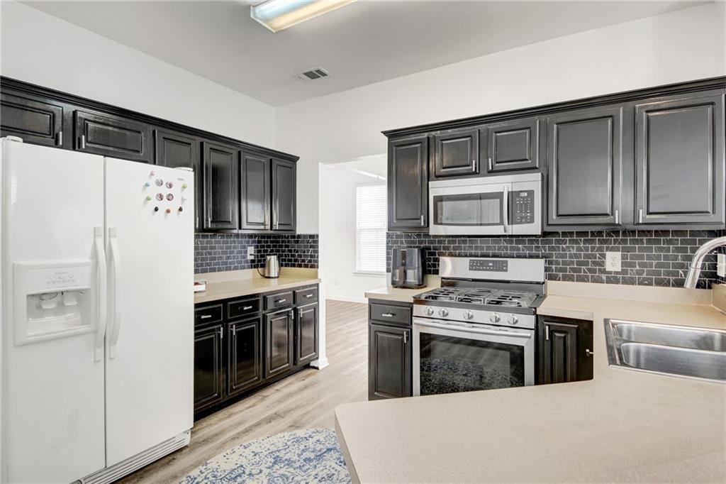 105 Fate Court Dallas, GA 30157 - Photo 10 of 32 a kitchen with stainless steel appliances a stove sink and refrigerator