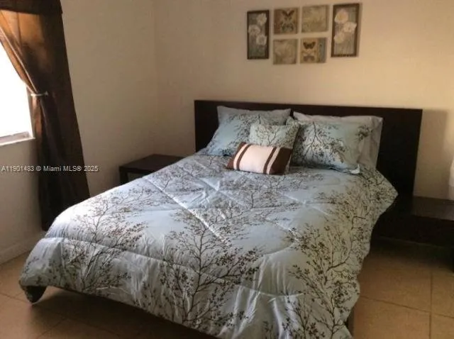 a bed sitting in a bedroom next to a window