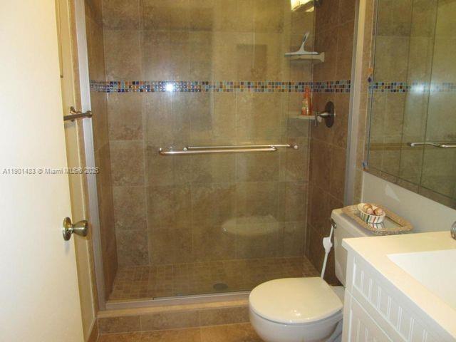 653 Waterside Drive, Unit 653 Hypoluxo, FL 33462 - Photo 8 of 12 a white toilet sitting next to a bathroom sink