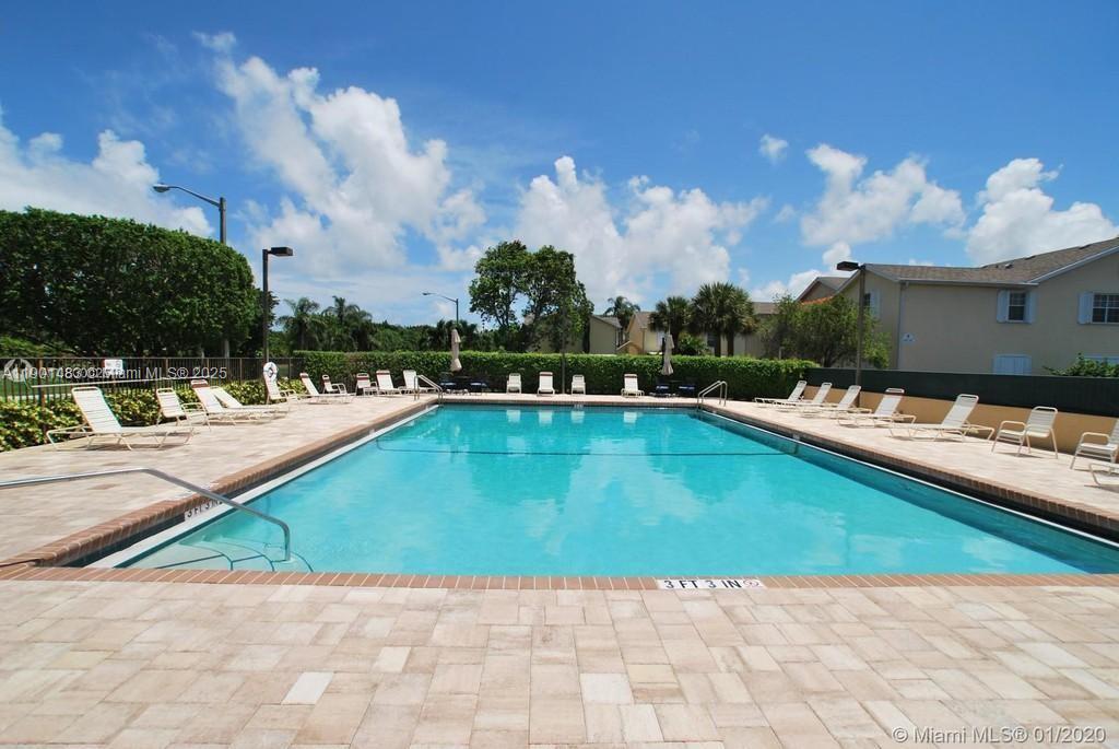 653 Waterside Drive, Unit 653 Hypoluxo, FL 33462 - Photo 9 of 12 a view of a swimming pool with a lounge chairs