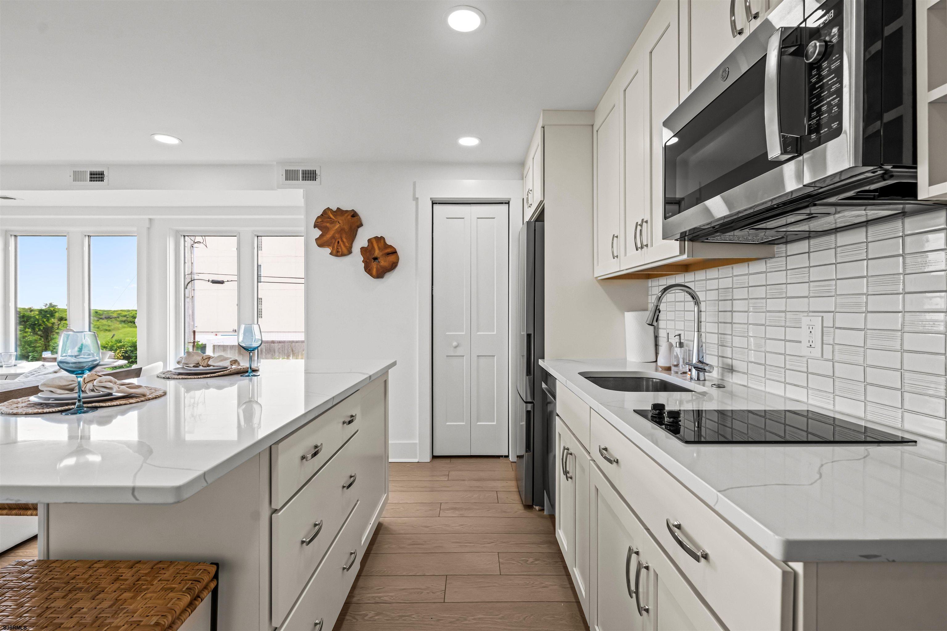 321 6th Street South, Unit 14 Brigantine, NJ 08203 - Photo 20 of 21 a kitchen with stainless steel appliances granite countertop a sink and stove top oven