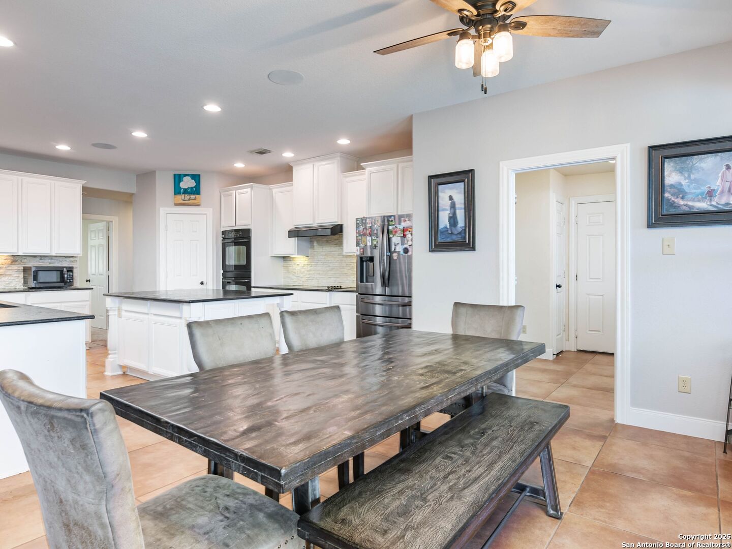 272 Schaper Road Fredericksburg, TX 78624 - Photo 15 of 62 a kitchen with granite countertop a table chairs stainless steel appliances and cabinets