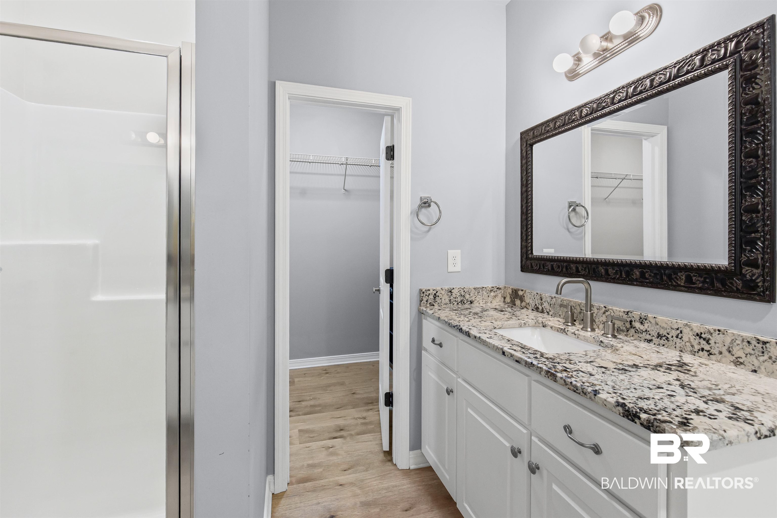 30851 Joseph Drive Spanish Fort, AL 36527 - Photo 14 of 22 Full bathroom featuring vanity, a walk in closet, light wood-style flooring, and a stall shower