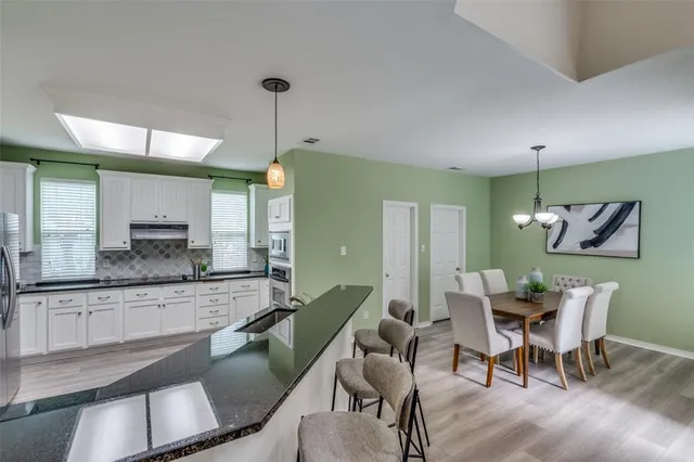 a dining room with furniture a chandelier and wooden floor
