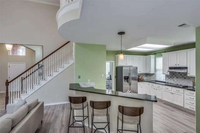 a kitchen with stainless steel appliances a stove top oven and a wooden floors