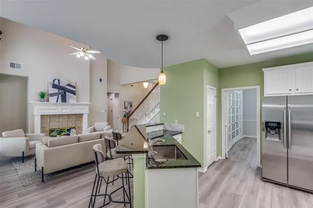 a kitchen with stainless steel appliances kitchen island granite countertop a table chairs in it and wooden floors