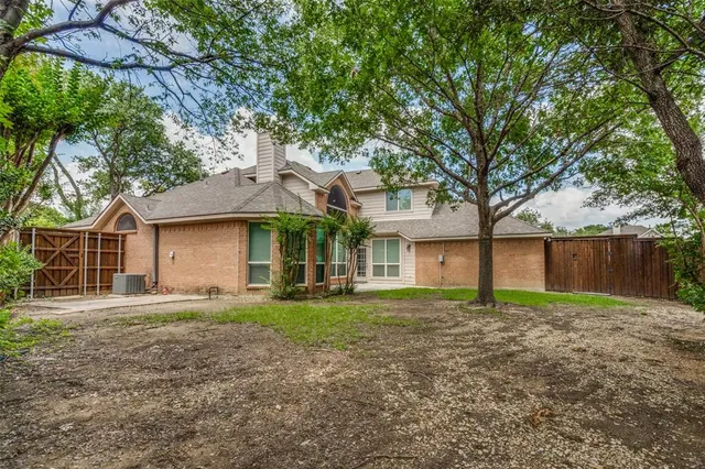 a front view of a house with a yard and trees
