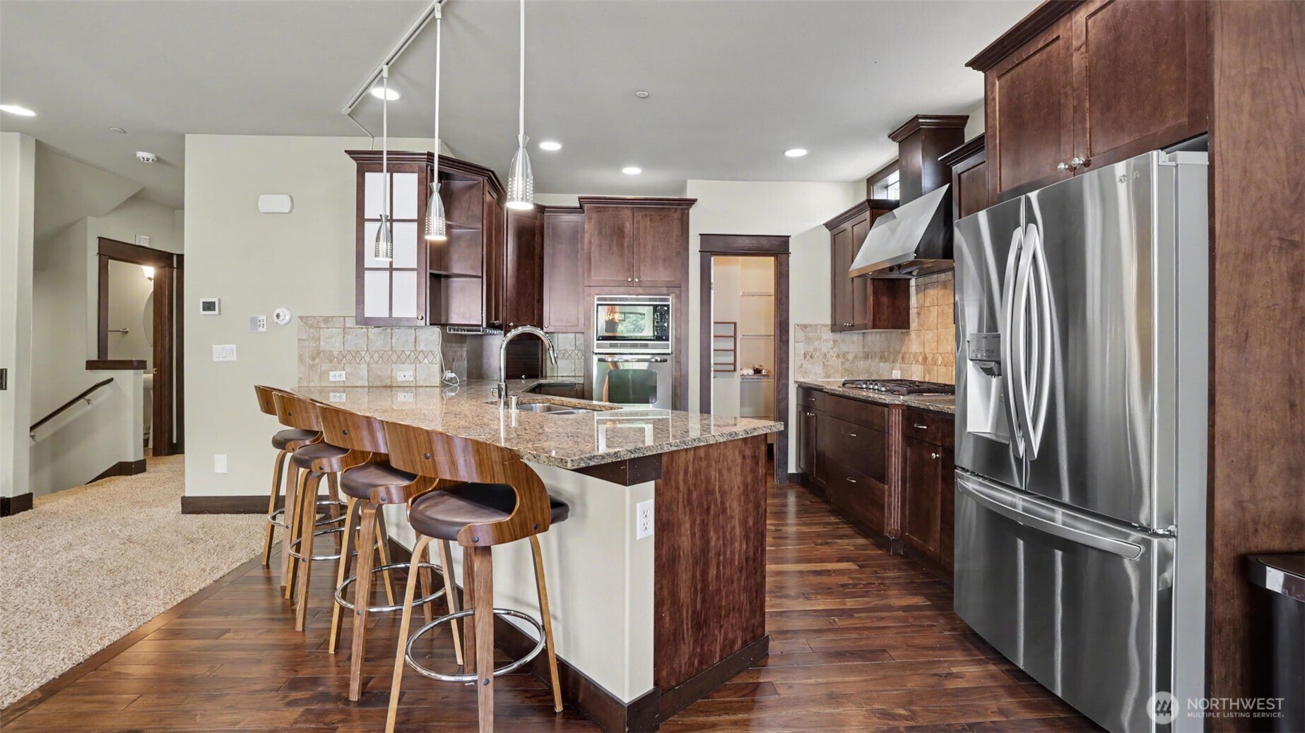 1357 Elma Place Northeast Renton, WA 98059 - Photo 8 of 40 a kitchen with stainless steel appliances kitchen island granite countertop a table chairs and a refrigerator