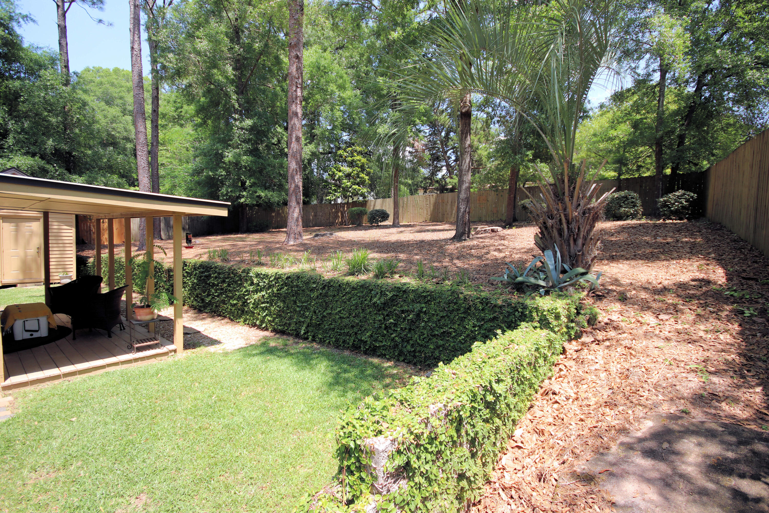 250 Panama Drive Crestview, FL 32536 - Photo 14 of 20 a view of a patio with table and chairs potted plants and large tree