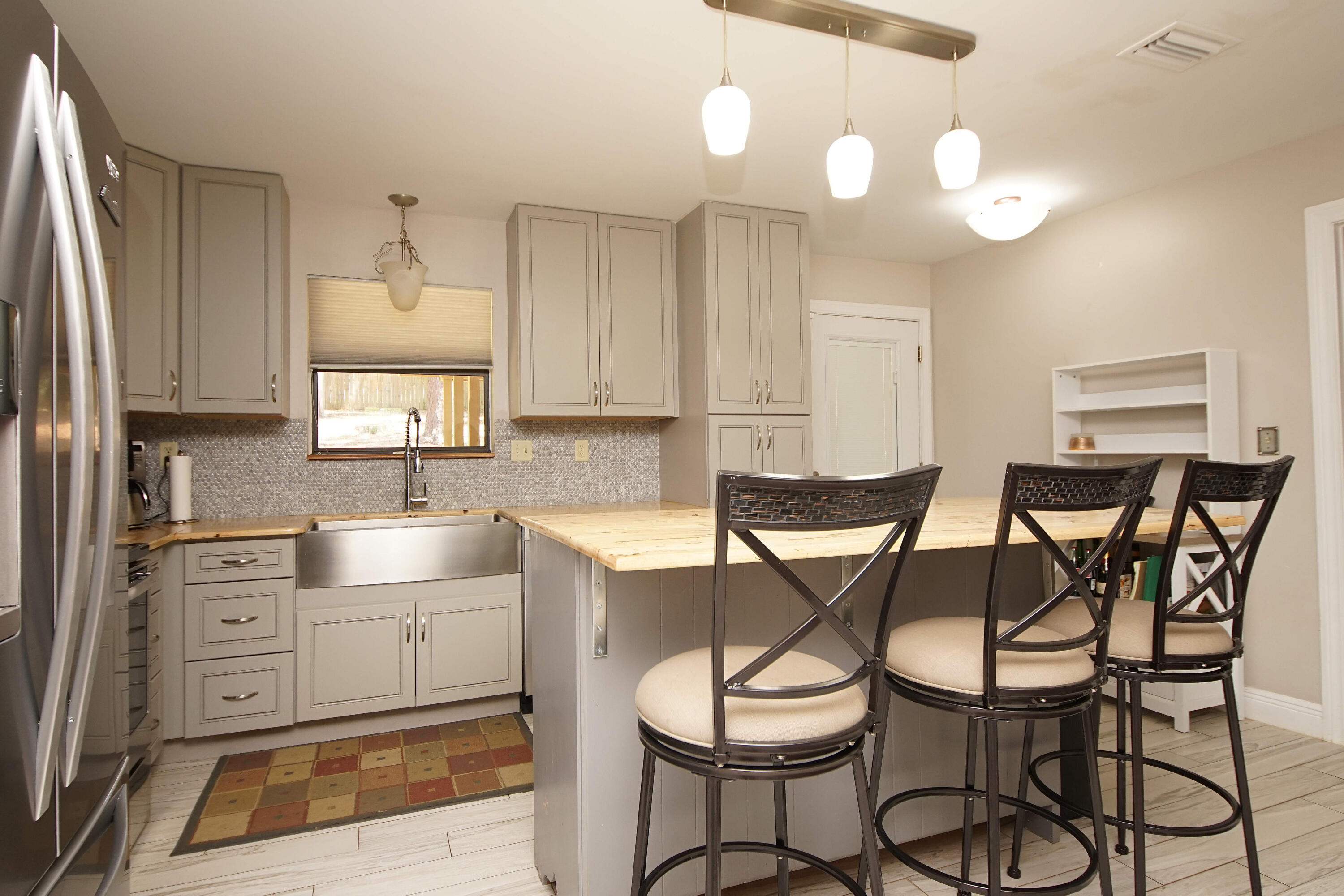 250 Panama Drive Crestview, FL 32536 - Photo 4 of 20 a kitchen with stainless steel appliances kitchen island granite countertop a table chairs sink and cabinets