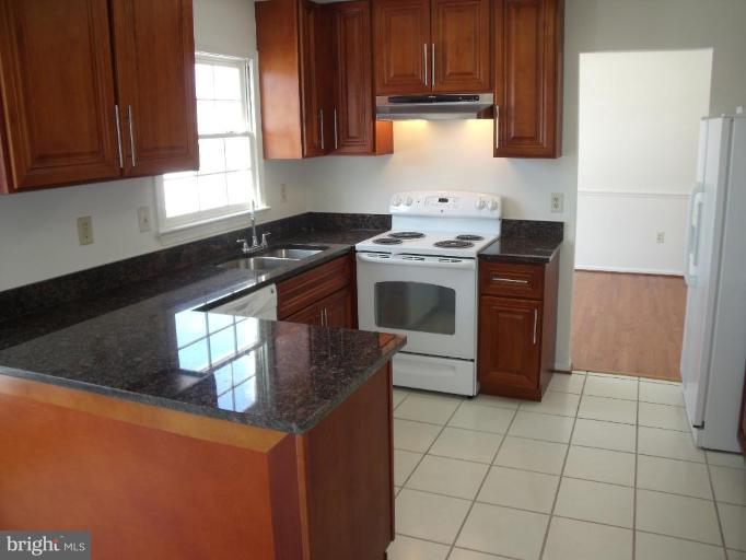 2963 Gracefield Road Silver Spring, MD 20904 - Photo 26 of 30 a kitchen with stainless steel appliances granite countertop a stove a sink and a refrigerator