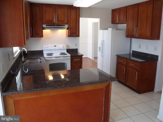 2963 Gracefield Road Silver Spring, MD 20904 - Photo 27 of 30 a kitchen with stainless steel appliances granite countertop a stove a refrigerator and a stove