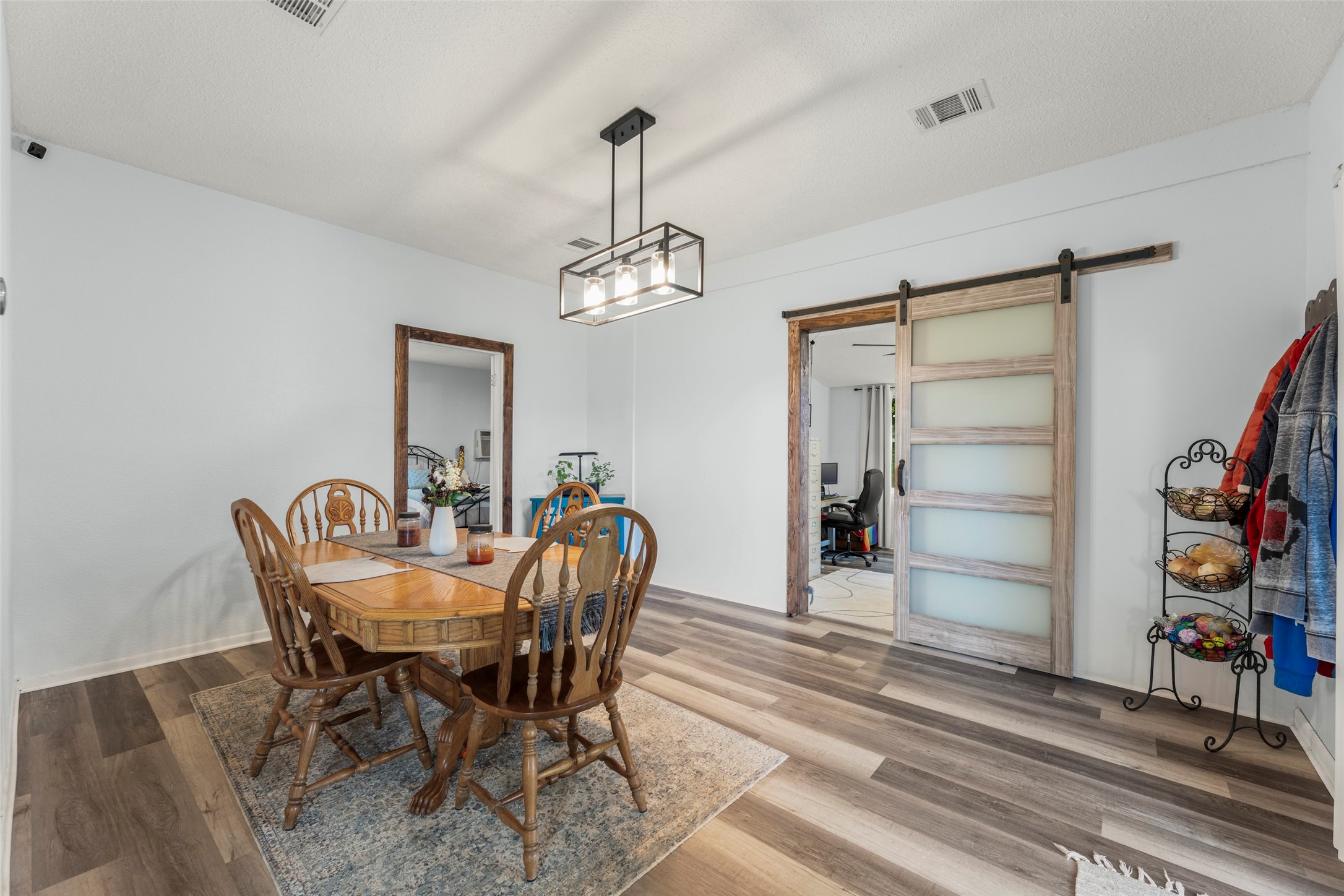 703 Pecan Valley Road Wharton, TX 77488 - Photo 16 of 47 The dining room is in the heart of the home. Just past that sliding barn door is the guest bedroom/office area.