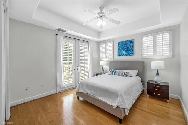 a bedroom with a bed chandelier and a window