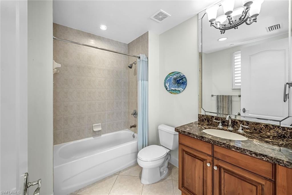 510 Avellino Isles Circle, Unit 2202 Naples, FL 34119 - Photo 17 of 35 a bathroom with a granite countertop sink a toilet a mirror a bathtub and shower