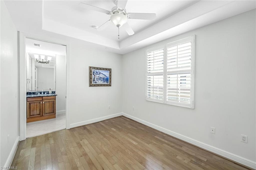 510 Avellino Isles Circle, Unit 2202 Naples, FL 34119 - Photo 20 of 35 wooden floor in an empty room with a window