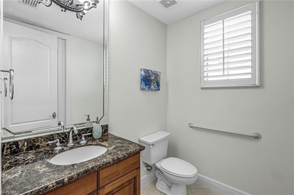 510 Avellino Isles Circle, Unit 2202 Naples, FL 34119 - Photo 21 of 35 a bathroom with a granite countertop sink a toilet a mirror and a window