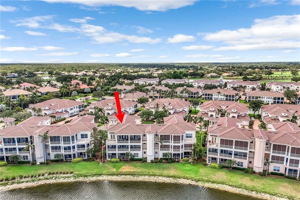 510 Avellino Isles Circle, Unit 2202 Naples, FL 34119 - Photo 27 of 35 an aerial view of a house with a garden and lake view