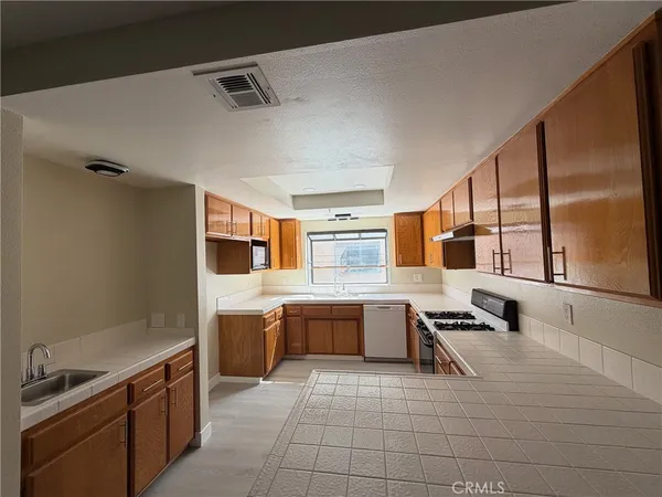 a kitchen with stainless steel appliances a stove a sink and a refrigerator