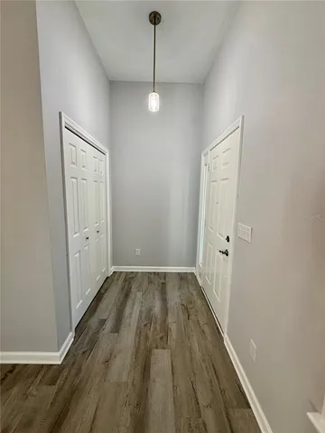 a view of a hallway with wooden floor and closet
