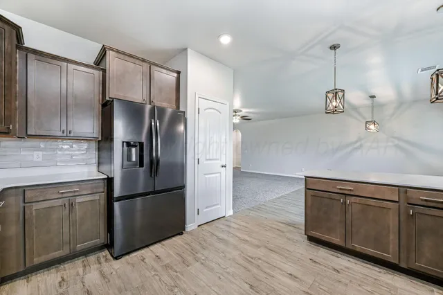 a kitchen with kitchen island white cabinets and stainless steel appliances