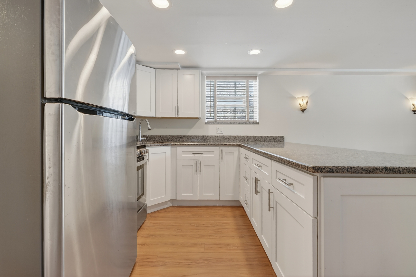 5101 North Kenton Avenue, Unit G Chicago, IL 60630 - Photo 12 of 25 a kitchen with granite countertop a refrigerator a sink and white cabinets