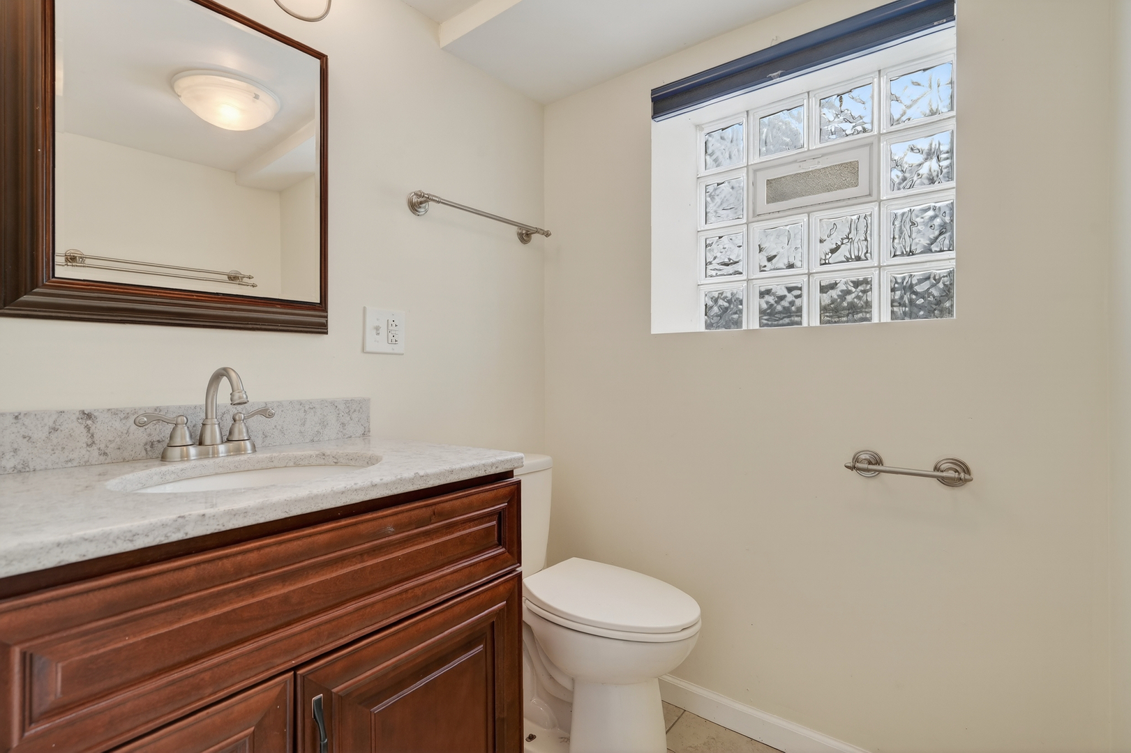 5101 North Kenton Avenue, Unit G Chicago, IL 60630 - Photo 20 of 25 a bathroom with a granite countertop sink mirror vanity and toilet