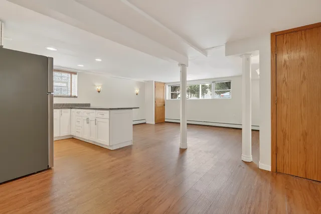 a view of a kitchen with wooden floor and electronic appliances