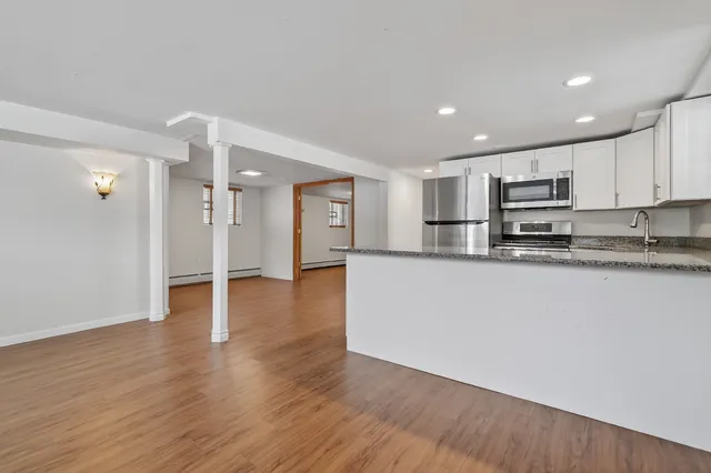 a view of kitchen with stainless steel appliances granite countertop a stove a sink and a refrigerator