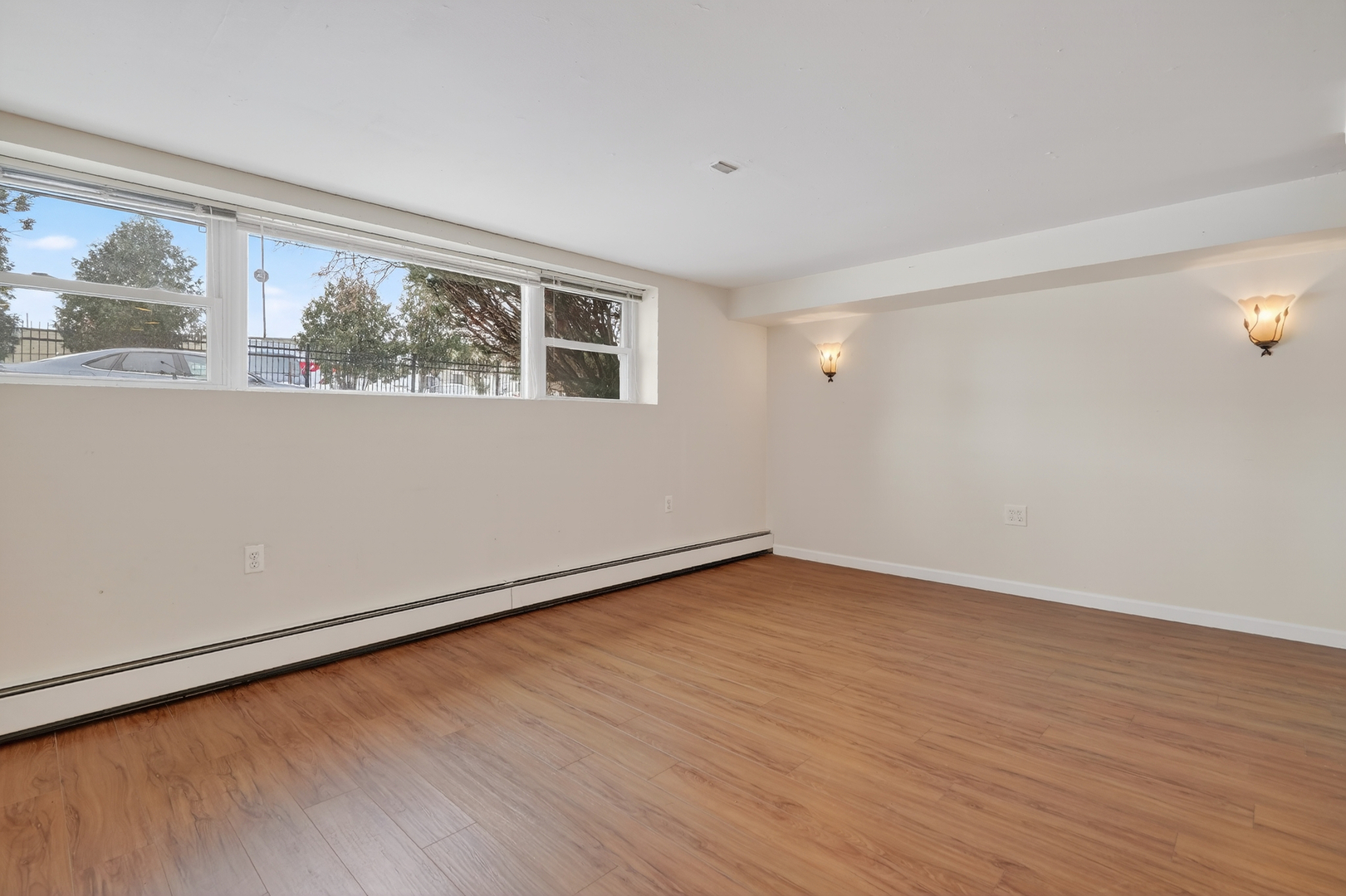 5101 North Kenton Avenue, Unit G Chicago, IL 60630 - Photo 5 of 25 a view of an empty room with wooden floor and a window