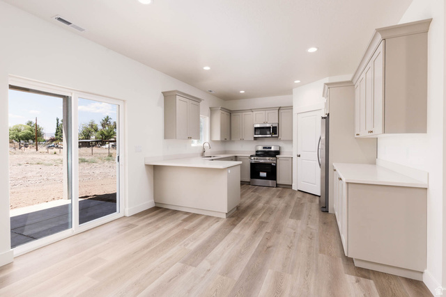 51 West 500 South Monroe, UT 84754 - Photo 12 of 41 Open-concept kitchen with light wood-finish flooring, recessed lighting, white countertops, and light gray cabinetry