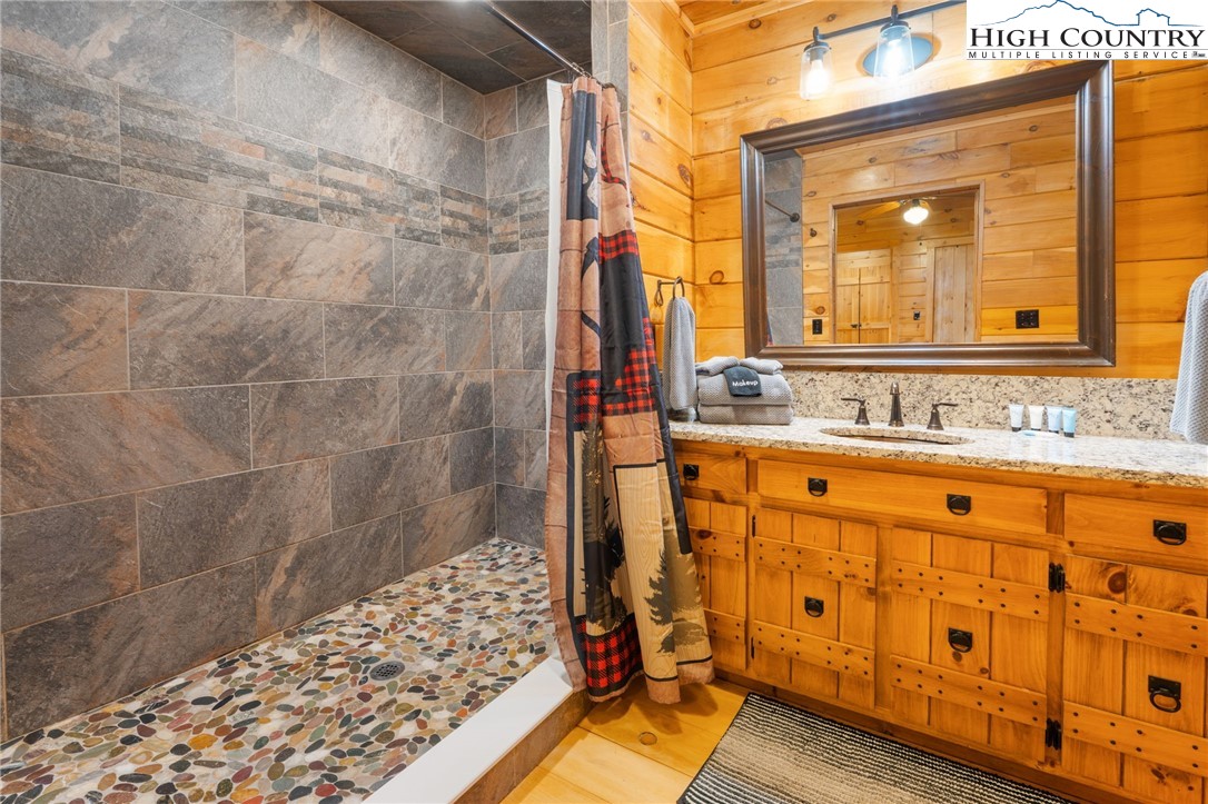 1748 Junaluska Road Boone, NC 28607 - Photo 27 of 37 a bathroom with a sink mirror and a shower