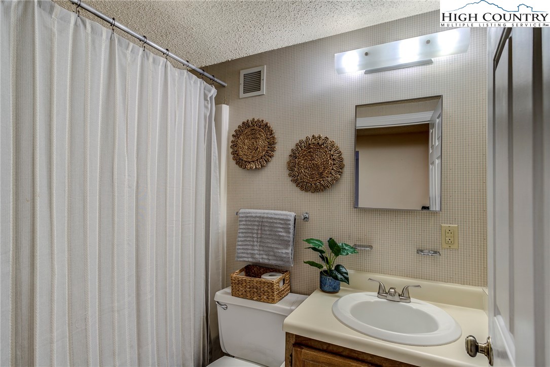 303 Sugar Top Drive, Unit 2313 Sugar Mountain, NC 28604 - Photo 13 of 39 a bathroom with a sink toilet and mirror