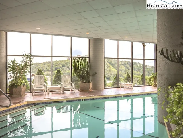 a swimming pool with outdoor seating and windows