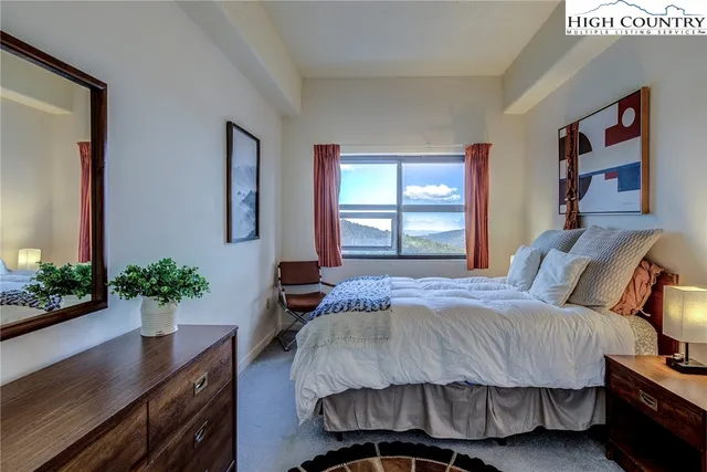 a bedroom with bed and a potted plant