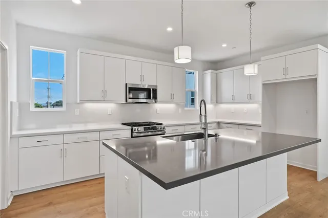 a kitchen with a sink a counter space and wooden floor
