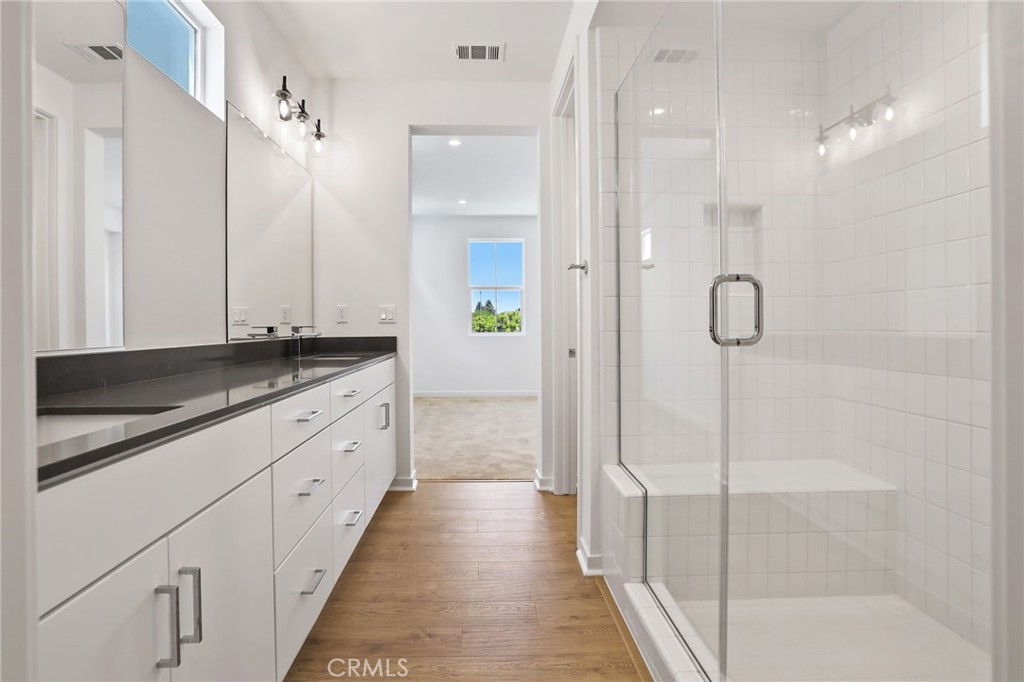 139 Jessup Way Tustin, CA 92780 - Photo 18 of 31 a bathroom with a granite countertop sink a shower and a mirror