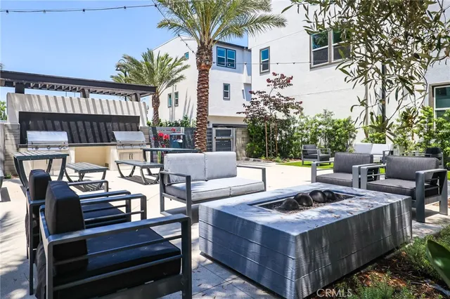 a view of a patio with couches table and chairs and potted plants